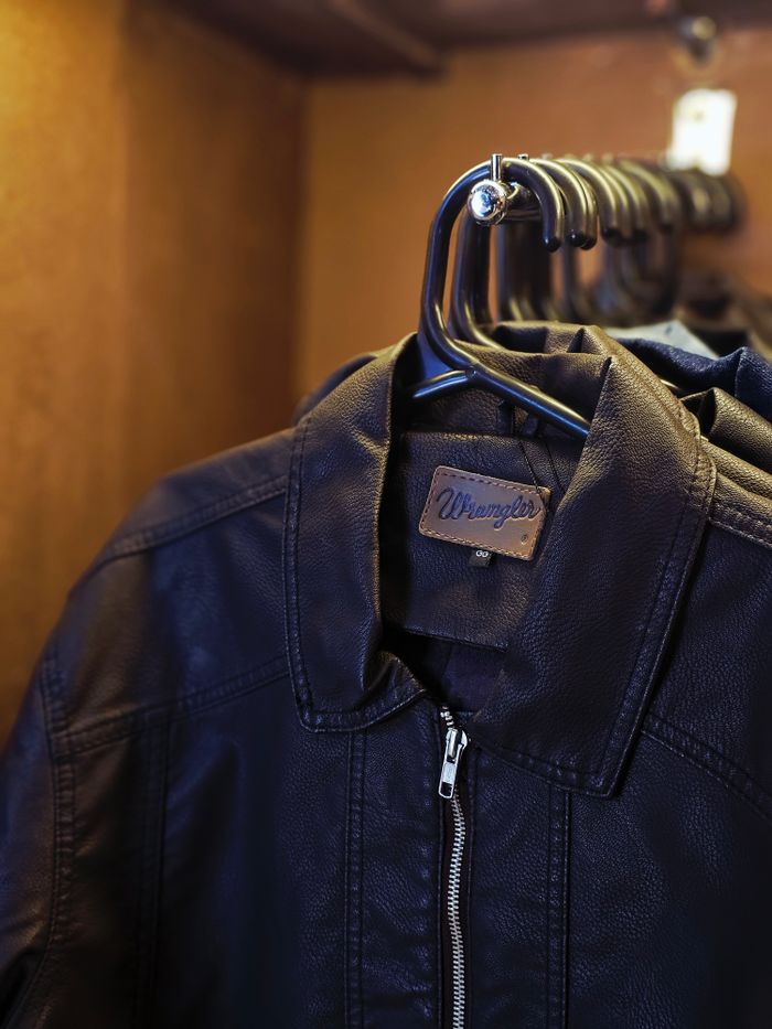 Stylish black leather jackets neatly hung on hangers inside a closet, showcasing fashion detail.